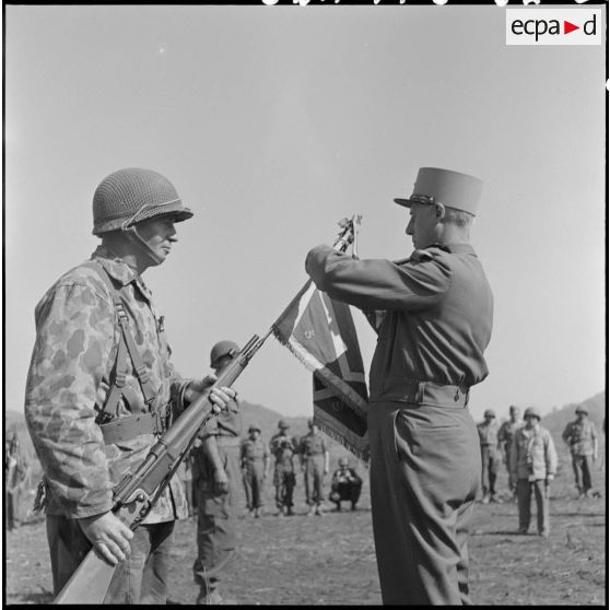 Le général Salan, commandant en chef en Indochine, remet la croix de guerre avec palme au fanion du 3e bataillon de parachutistes coloniaux (3e BPC), qui s'est illustré pendant la bataille de Na San.