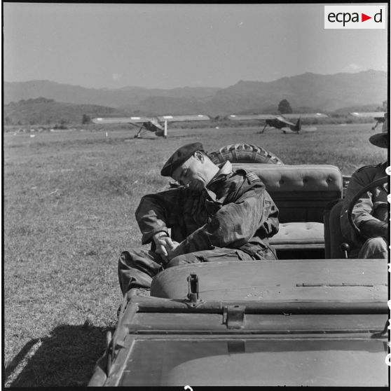 Un lieutenant-colonel des troupes aéroportées se reposant dans un jeep sur le terrain d'aviation de Diên Biên Phu.