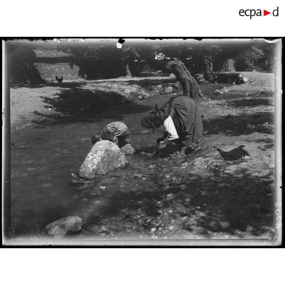 [Macédoine, Radogo-Bas. Dans un village, une femme et un enfant lavent du linge dans une rivière.]