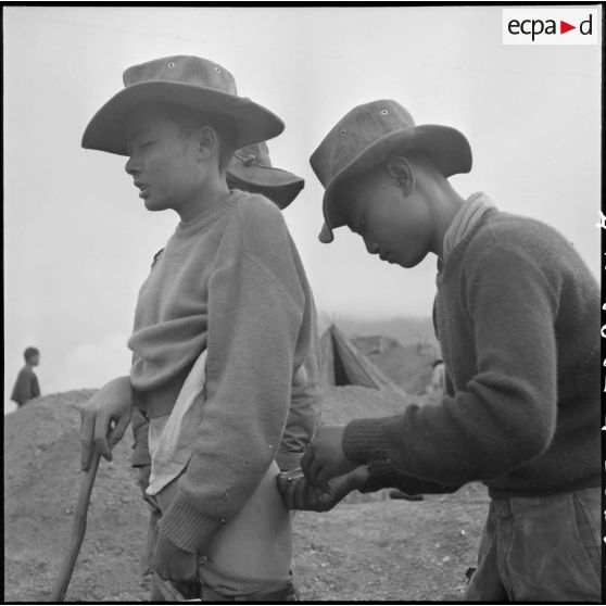 Un infirmier vaccine un chasseur laotien qui participe à l'aménagement d'un point d'appui à Muong Khoua.