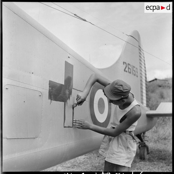 Peinture du signe de la Croix-Rouge sur un avion sanitaire Beaver servant au rapatriement des blessés de Diên Biên Phu.