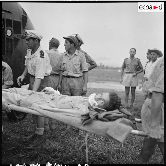 Evacuation des premiers grands blessés de Diên Biên Phu arrivés par hélicoptère Sikorsky sur le terrain d'aviation de Luang Prabang.