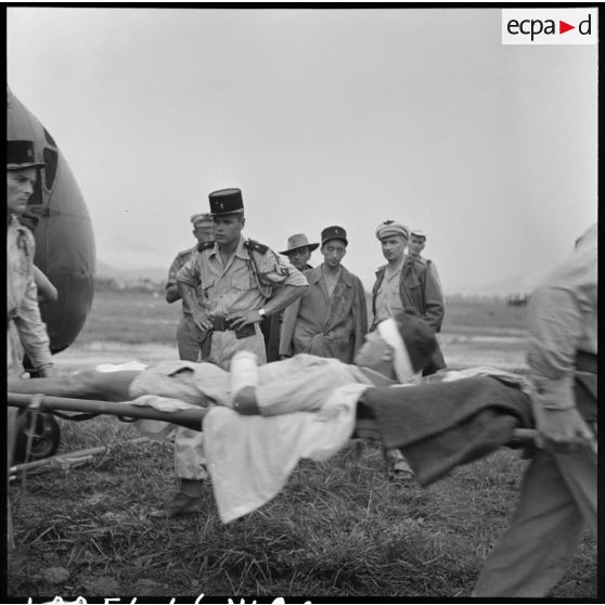 Evacuation des premiers grands blessés de Diên Biên Phu arrivés par hélicoptère Sikorsky sur le terrain d'aviation de Luang Prabang.