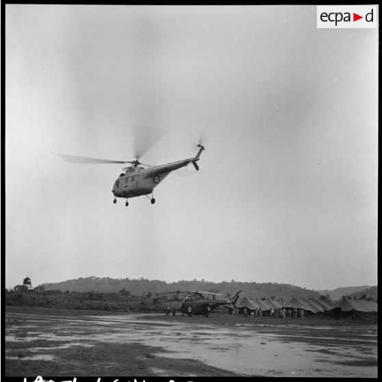 Arrivée des premiers grands blessés de Diên Biên Phu par hélicoptère Sikorsky sur le terrain d'aviation de Luang Prabang.