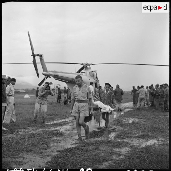 Evacuation des premiers grands blessés de Diên Biên Phu arrivés par hélicoptère Sikorsky sur le terrain d'aviation de Luang Prabang.