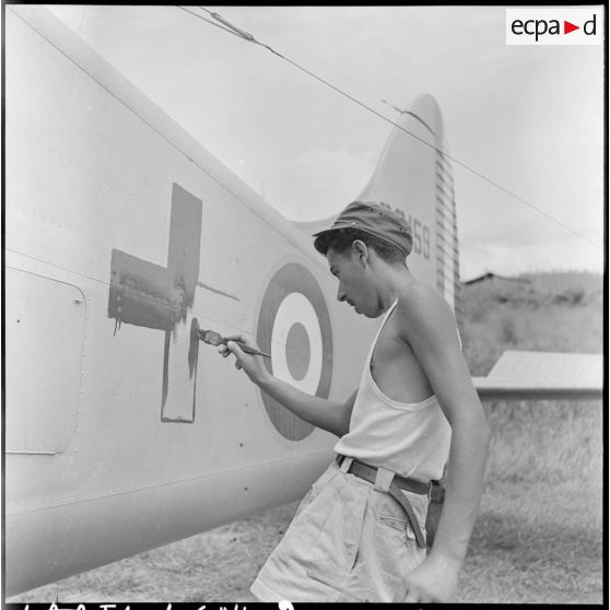 Peinture du signe de la Croix-Rouge sur un avion sanitaire Beaver servant au rapatriement des blessés de Diên Biên Phu.