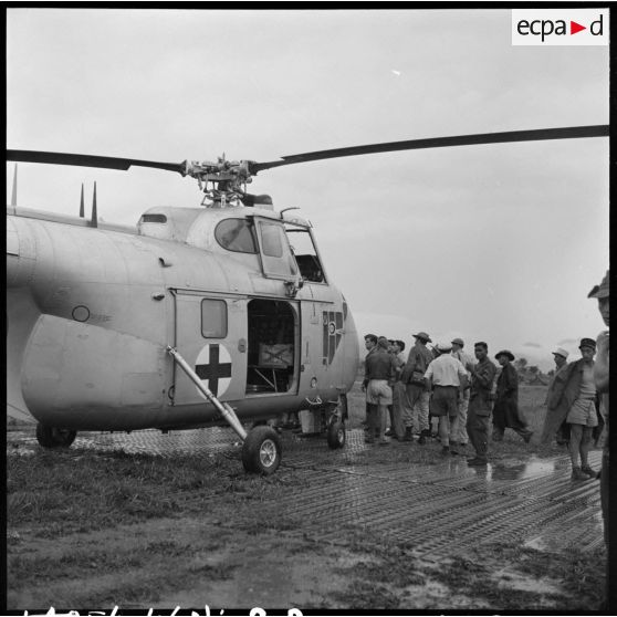 Arrivée des premiers grands blessés de Diên Biên Phu par hélicoptère Sikorsky sur le terrain d'aviation de Luang Prabang.