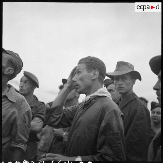 Portrait d'un pilote et de militaires sur le terrain d'aviation de Luang Prabang lors de l'arrivée de blessés de Dien Biên Phu.