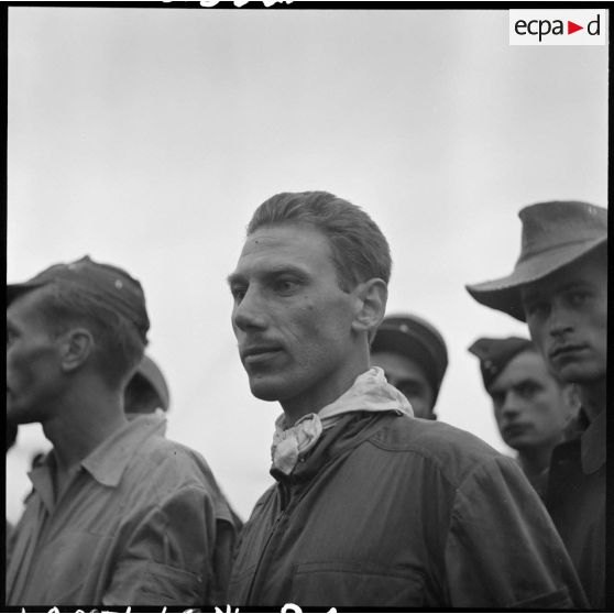 Portrait d'un pilote et de militaires sur le terrain d'aviation de Luang Prabang lors de l'arrivée de blessés de Dien Biên Phu.