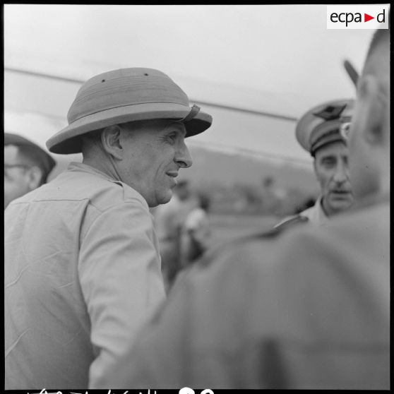 Le professeur Huard, membre de la délégation française chargée de négocier avec le Viêt-minh la libération des prisonniers de DIên Biên Phu, s'entretient avec le journaliste Max Clos sur le terrain d'aviation de Luang Prabang.