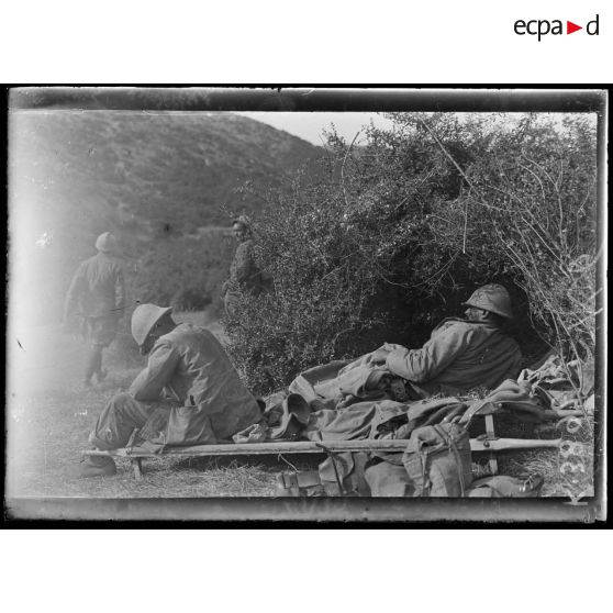 Ravin de Valadja (Macédoine). Poste de secours, un blessé couché sur un brancard et un fiévreux assis. [légende d'origine]