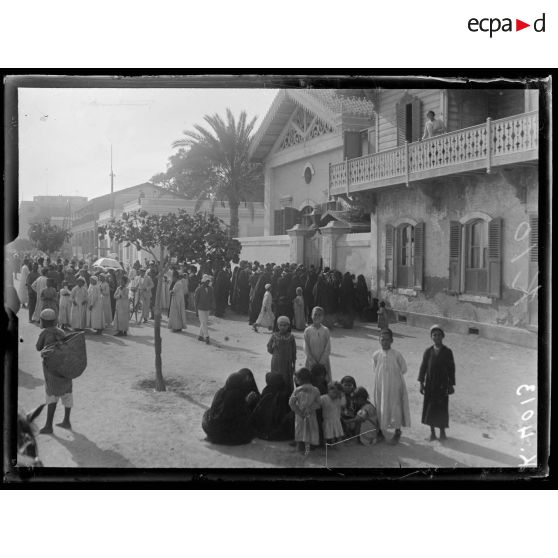 Port-Saïd, devant l'hôpital. Les femmes se lamentent. On vient de porter les morts et  blessés à l'hôpital ; le bâtiment lui-même a été touché par une bombe tombée dans la rue. [légende d'origine]