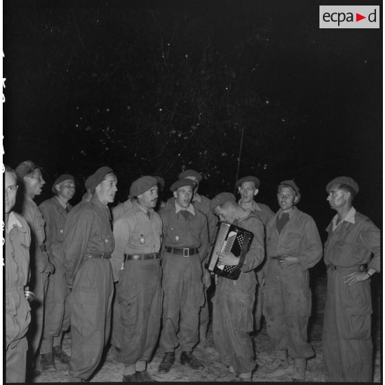 Après la messe de minuit à Diên Biên Phu, des légionnaires de la 13e demi-brigade de Légion étrangère (DBLE) chantent des cantiques devant le sapin.