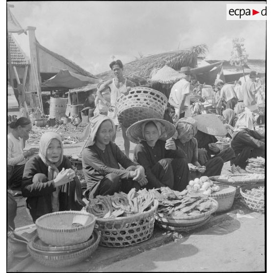 Scène de marché avec des vendeurs ambulants dans les rues de Saigon.