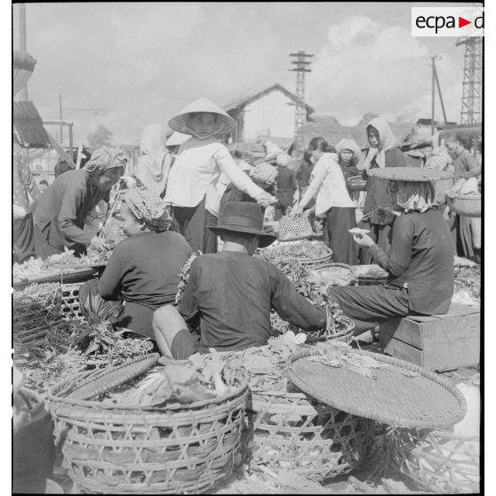 Scène de marché avec des vendeurs ambulants dans les rues de Saigon.