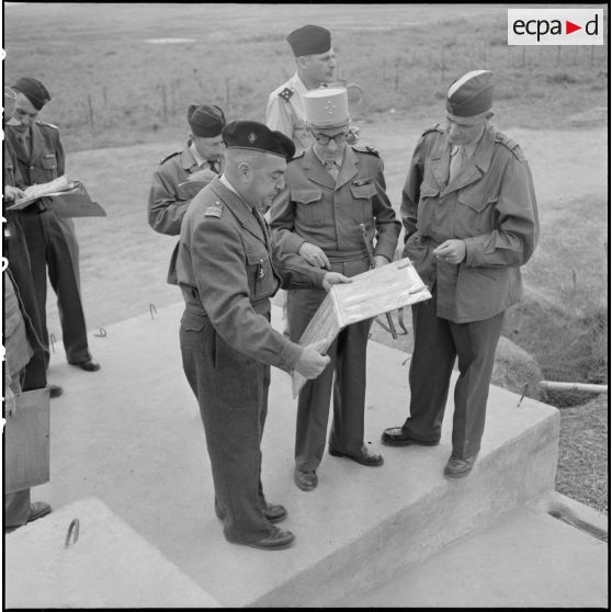 Au cours d'une inspection du général Navarre au poste de Thuy Phieu, examen de la carte avec le colonel Quilichini, commandant le secteur (à gauche) et le colonel De Clerk (à droite) commandant la 1e division militaire territoriale (DMT).