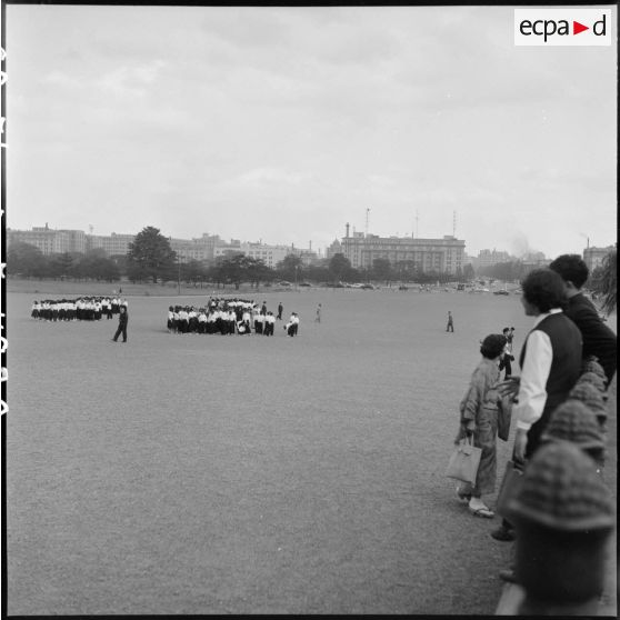 Promeneurs et groupe d'étudiants sur la place du palais impérial à Tokyo.