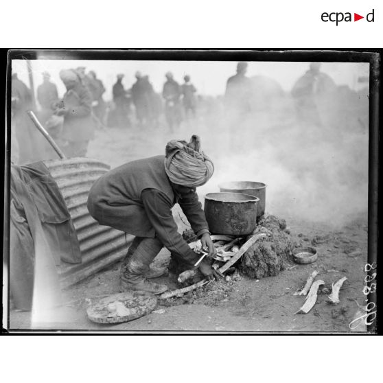 Camp d'aviation d'Azelot, un cuisinier prépare le feu. [légende d'origine]