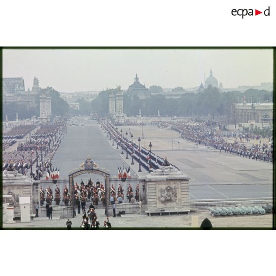 Dispositif des troupes avant le défilé du 14 juillet 1977 devant l'esplanade les Invalides, sur l'avenue du maréchal Galliéni et le pont Alexandre III, le Grand Palais et le Petit Palais en perspective.