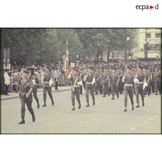 Défilé à pied lors de la cérémonie du 14 juillet 1977 place Joffre devant l'Ecole militaire. Passage du drapeau et de sa garde d'une unité, peut-être le 3e régiment d'infanterie de marine (3e RIMa).