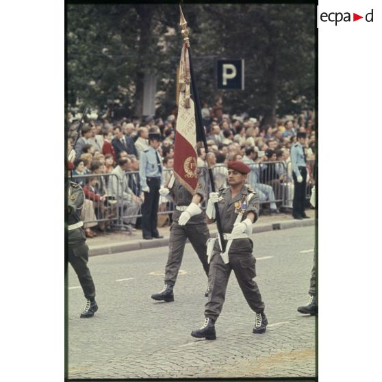 Défilé à pied lors de la cérémonie du 14 juillet 1977 place Joffre devant l'Ecole militaire. Passage du drapeau et de sa garde d'une unité parachutiste d'infanterie de marine, peut-être le 1er RPIMa.