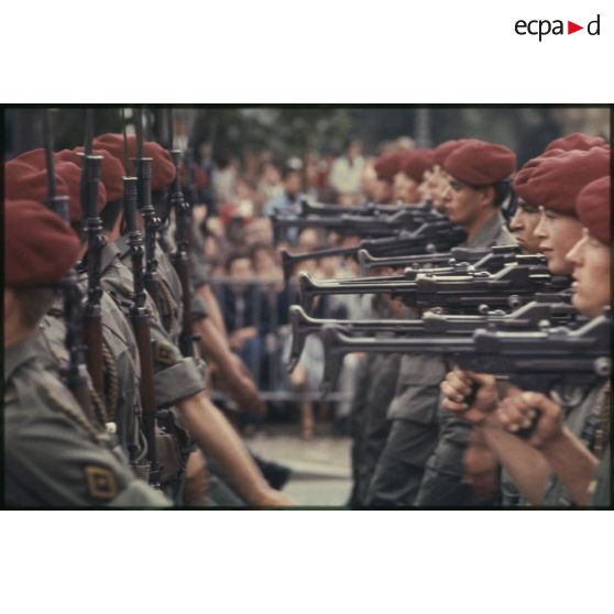 Défilé à pied lors de la cérémonie du 14 juillet 1977 place Joffre devant l'Ecole militaire. Passage d'une unité parachutiste, peut-être le 9e régiment de chasseurs parachutistes (9e RCP), équipée de mitrailleuses AA-52.