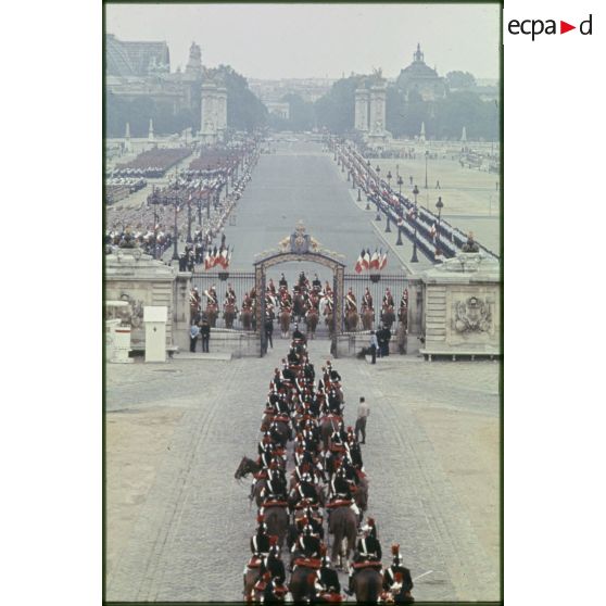 Dispositif des troupes avant le défilé du 14 juillet 1977 devant l'esplanade les Invalides, sur l'avenue du maréchal Galliéni et le pont Alexandre III, le Grand Palais et le Petit Palais en perspective.