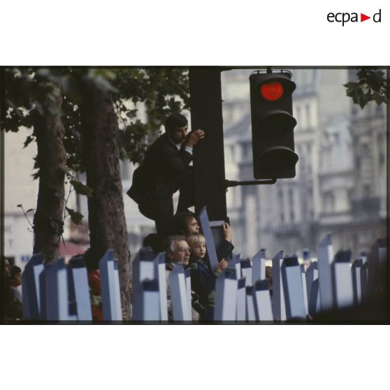 Lors du défilé du 14 juillet 1979 à la Bastille, le public, équipé de périscopes en papier, ou perché sur le poteau d'un feu de circulation pour mieux voir.