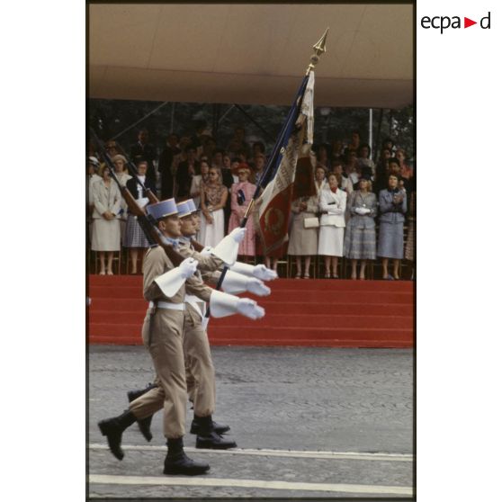 Défilé à pied lors de la cérémonie du 14 juillet 1979 à la Bastille. Passage du drapeau et de sa garde de l'école nationale des sous-officiers d'active (ENSOA) de Saint-Maixent devant la tribune des Dames.