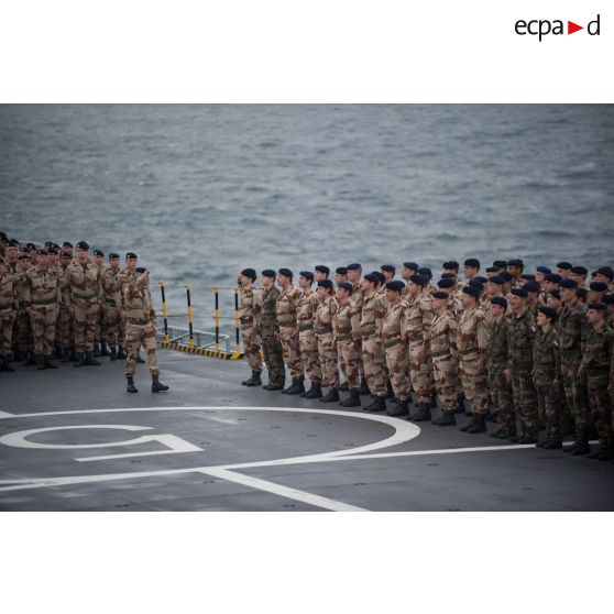 Le colonel Bruno Bert passe les soldats du groupement tactique interarmes (GTIA) en revue sur le pont du bâtiment de projection et de commandement Dixmude (L9015) à Toulon.