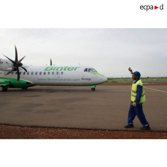 Un personnel de piste malien donne le départ pour le décollage d'un avion ATR-72 sur l'aéroport de Bamako-Sénou, au Mali.