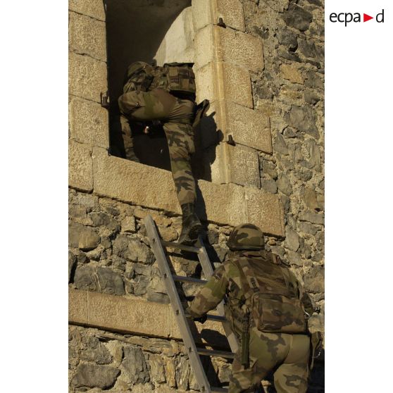 Progression sur une échelle de chasseurs du 7e BCA (Bataillon de chasseurs alpins) lors d'un entraînement au combat local. Les hommes pénètrent dans une maison.