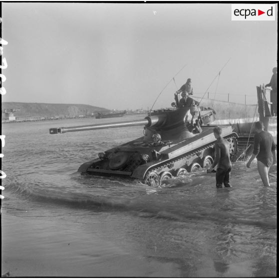 Un char AMX 13 débarque d’une barge. [Description en cours]