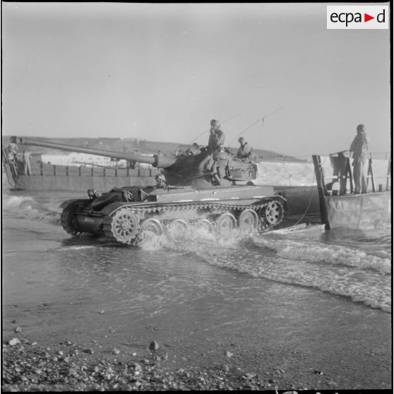 Un char AMX 13 débarque d’une barge. [Description en cours]