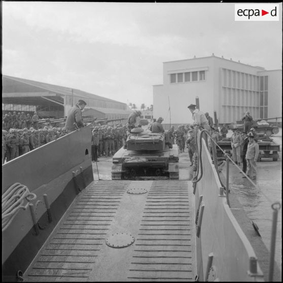 Un char AMX 13 débarque d’une barge. [Description en cours]