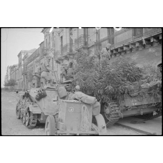 Un semi-chenillé (leichter Munition-Panzerwagen, Sd.kfz.250/6) et sa remorque approvisionnent en obus un canon d'assaut Sturmgeschütz III de la III./Panzer-Regiment  Hermann Goering.