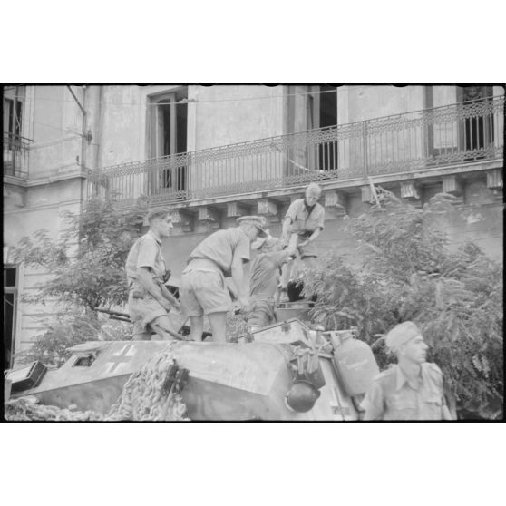 Un semi-chenillé (leichter Munition-Panzerwagen, Sd.kfz.250/6) et sa remorque approvisionnent en obus un canon d'assaut Sturmgeschütz III de la III./Panzer-Regiment  Hermann Goering.