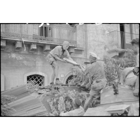 Un semi-chenillé (leichter Munition-Panzerwagen, Sd.kfz.250/6) et sa remorque approvisionnent en obus un canon d'assaut Sturmgeschütz III de la III./Panzer-Regiment  Hermann Goering.