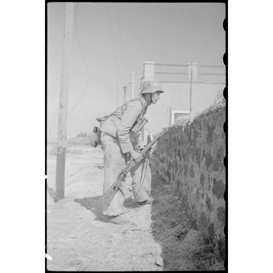 A Catane (Sicile) ou dans la banlieue de la ville, un fantassin du Panzergrenadier-Regiment Hermann Goering épaule son fusil Mauser 98k.