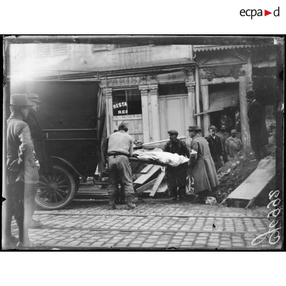 Nancy, enlèvement du corps d'une victime du bombardement rue Saint-Jean. [légende d'origine]