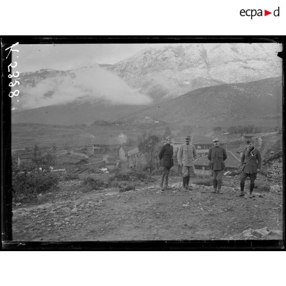 [A Bratomir, photographie de groupe rassemblant des autorités militaires devant un village, en pleine montagne.]