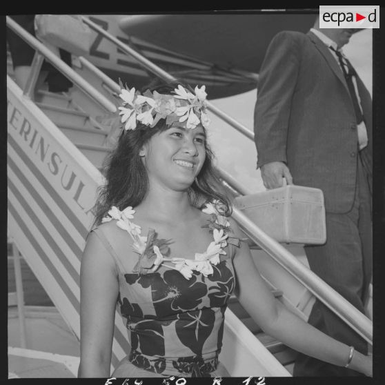 Portrait d'une hôtesse polynésienne en tenue traditionnelle de l'aéroport de Faa'a à Papeete, qui offre des colliers de fleurs aux passagers à leur descente de l'avion.