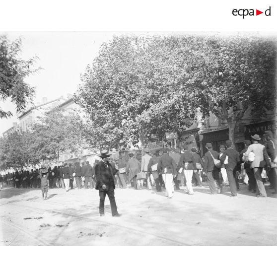 224. [France, 1922. Militaires marchant de dos dans une rue.]