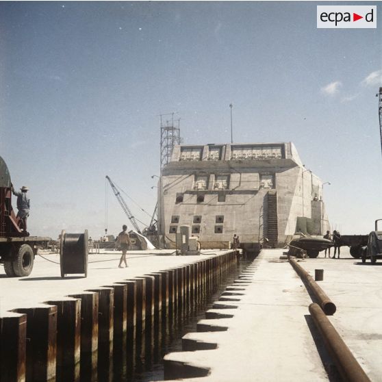 Construction du bunker du poste d'enregistrement avancé (PEA) Denise [ou Dindon] à Moruroa, avec son chenal qui mène au lagon.