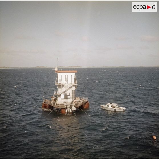 Vue aérienne de la barge au point zéro dans le lagon de l'atoll de Moruroa. La croix marque l'emplacement de l'engin nucléaire (tir Aldébaran).