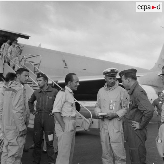 Arrivée d'un avion C-135F à Hao. Accueil de l'équipage par le général de corps aérien Philippe Maurin, commandant en chef des forces aériennes stratégiques (FAS), le commandant André Dubroca, pilote du Mirage IVP 9, le colonel Dugit-Gros commandant la base avancée de Hao, et le copilote capitaine Caubert .