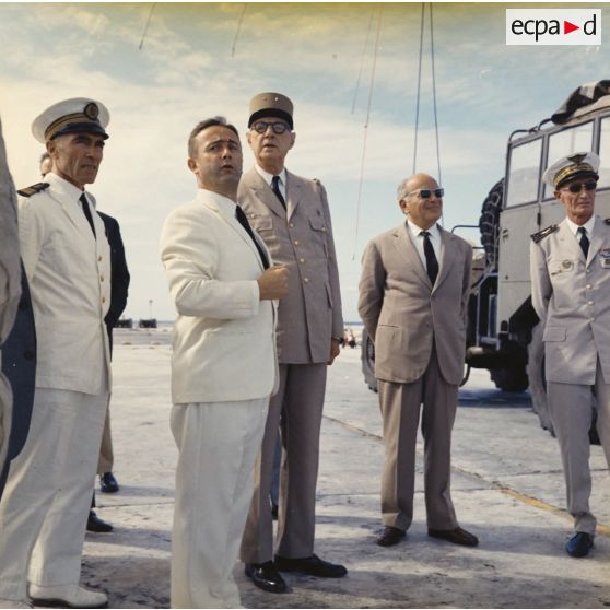 Le général Charles De Gaulle, président de la République, visite le site du poste d'enregistrement avancé (PEA) Denise, en compagnie de Jean Viard, directeur des essais. En arrière-plan, un camion Berliet auquel est arrimé le ballon du prochain tir Bételgeuse.