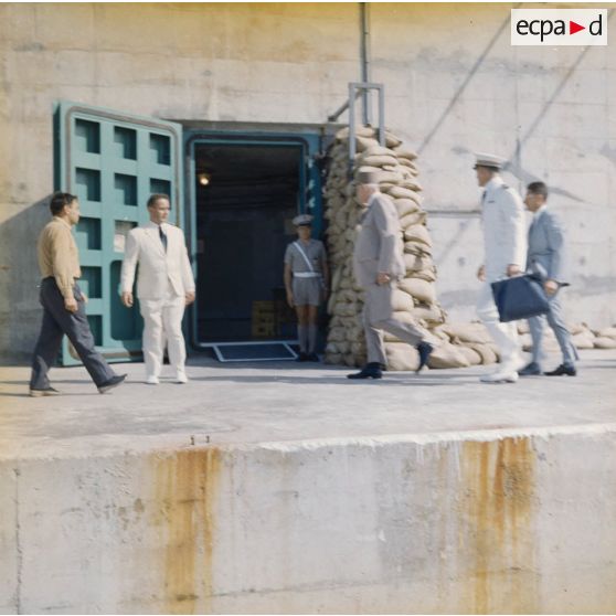 Le général Charles De Gaulle, président de la République, à l'entrée du bunker du poste d'enregistrement avancé (PEA) Denise, en compagnie de Jean Viard, directeur des essais.