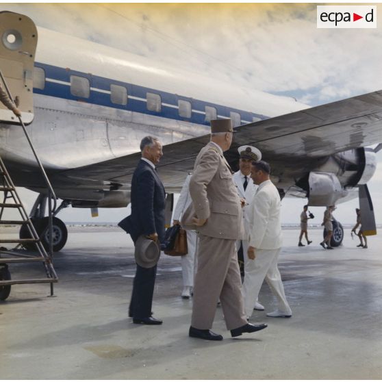 Le général Charles De Gaulle, président de la République, Pierre Messmer, ministre des Armées, au pied de l'avion à l'aéroport de Moruroa, accueillis par Jean Viard, directeur des essais, et le vice-amiral d’escadre Jean Lorain, commandant du groupe opérationnel des expérimentations nucléaires (GOEN).