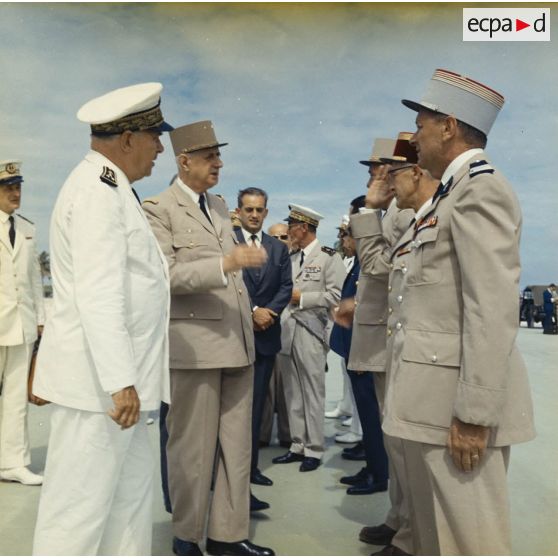 Le général Charles De Gaulle, président de la République, se fait présenter par le vice-amiral Jean Lorain, commandement du groupe opérationnel des expérimentations nucléaires (GOEN), les officiers supérieurs du site.